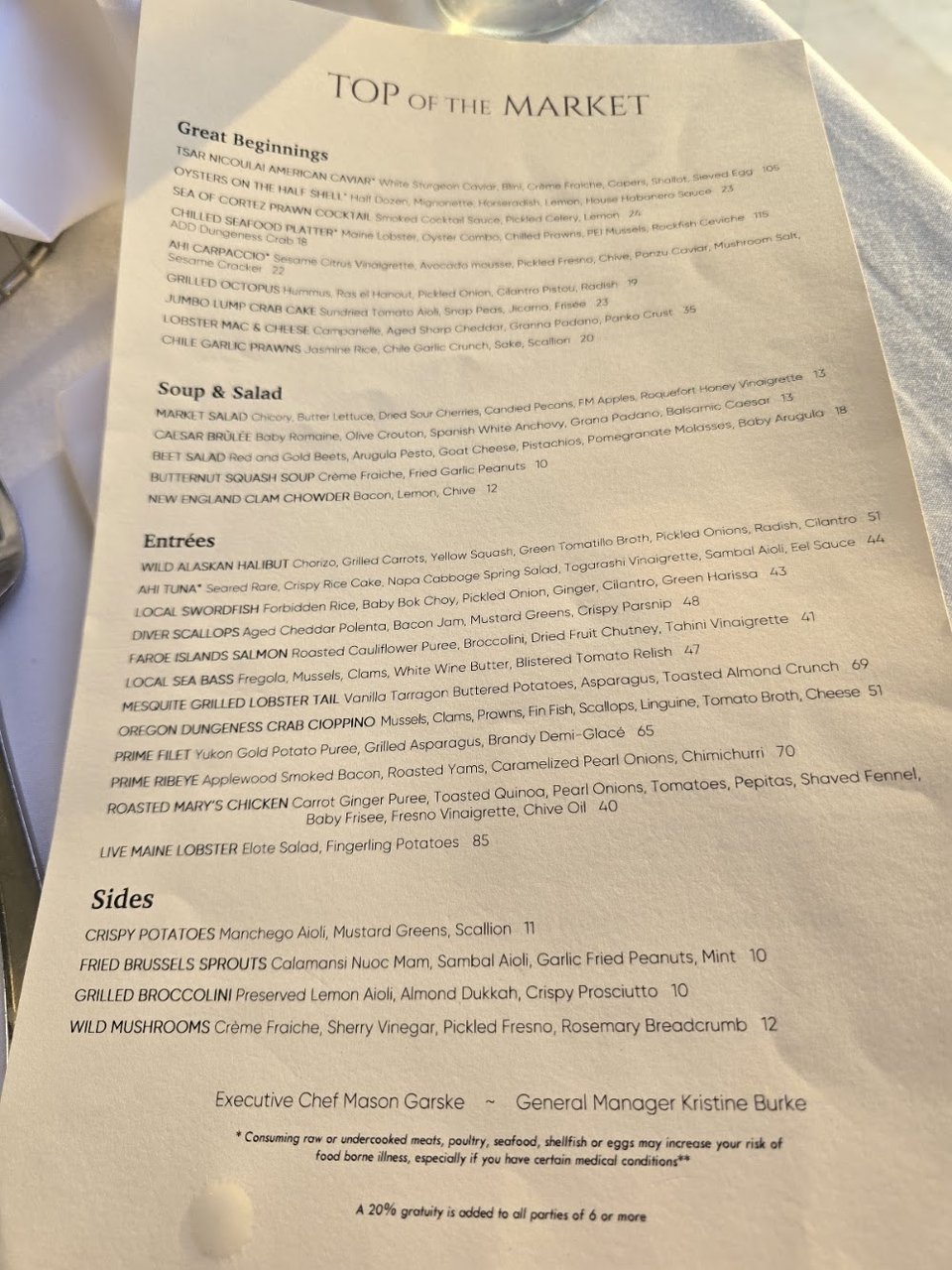 Restaurant menu beside a polished table setting.